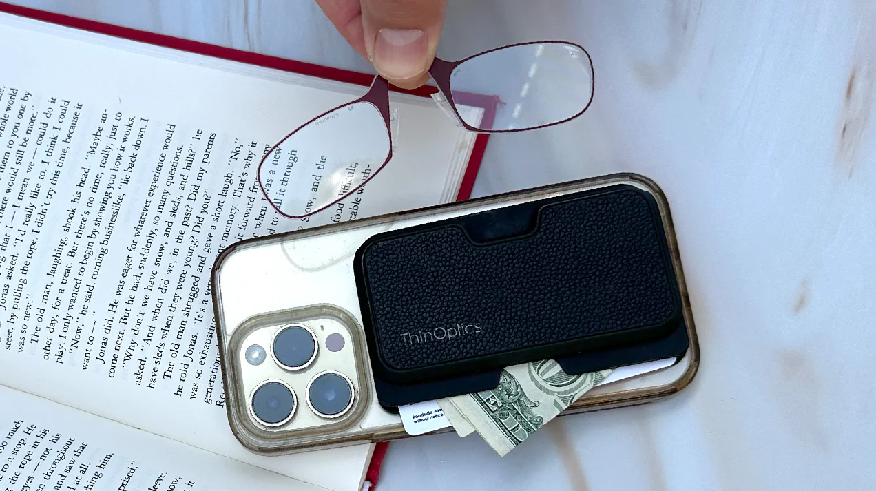 Woman smiling while reading a menu with ThinOptics reading glasses